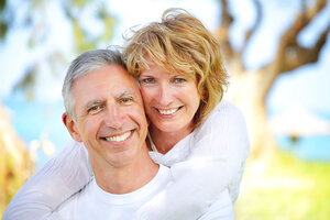mature couple outdoors near beach and trees, smiling nice teeth. Camarillo, CA dental implants